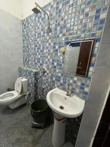 a bathroom with a toilet and a sink and a mirror at Priyakant inn in Vrindāvan