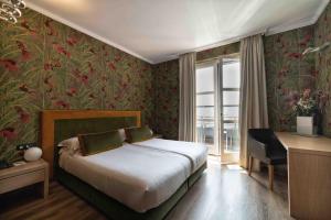 a bedroom with a bed and a desk and a window at Phi Hotel Piajo in Nembro +63 photos