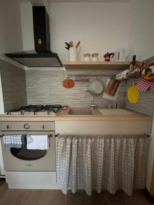 een keuken met een fornuis en een spoelbak bij Casa Zoe in Ameno