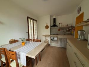 een keuken met een houten tafel en een keuken met een tafel en stoelen bij Casa Zoe in Ameno