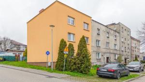 a yellow building on the side of a street at Apartamenty Sun & Snow Wojska Polskiego Puck in Puck