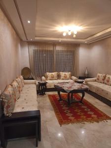 - un salon avec un canapé et une table dans l'établissement Nouaceur Garden Airport Casablanca, à Nouaseur