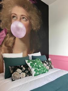 Una mujer con un globo en la boca junto a una cama. en Le Clos Gabrielle en Châtellerault