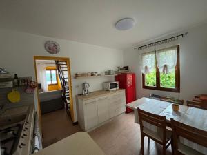 een keuken met een tafel en een rode koelkast bij Casa Zoe in Ameno +42 foto's