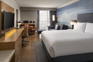 a hotel room with a bed and a flat screen tv at Courtyard by Marriott Long Beach Downtown in Long Beach