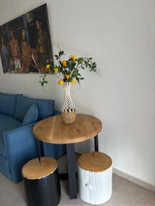 a vase with flowers on a table with two stools at The MITS luxury apartments in Skiathos Town