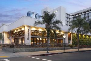 un edificio bianco con palme di fronte di Courtyard by Marriott Long Beach Downtown a Long Beach