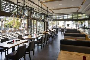 un restaurante con mesas, sillas y ventanas en Courtyard by Marriott Long Beach Downtown en Long Beach