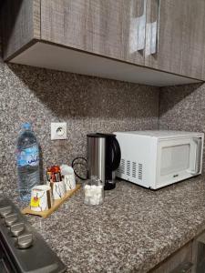 een aanrecht met een magnetron en een koffiezetapparaat bij Nouaceur Garden Airport Casablanca in Nouaseur