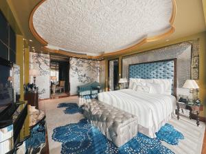 a bedroom with a large bed with a blue headboard at The Reverie Saigon in Ho Chi Minh City