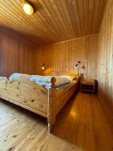 Cama grande de madera en habitación con suelo de madera en Tyinkrysset panorama, en Tyinkrysset