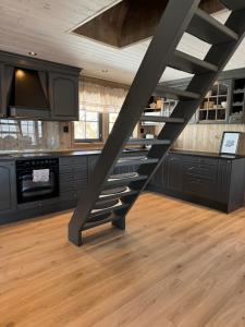 a staircase in a kitchen with black cabinets at Tyinkrysset panorama in Tyinkrysset