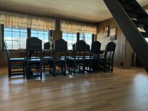 une salle à manger avec une table et des chaises noires dans l'établissement Tyinkrysset panorama, à Tyinkrysset