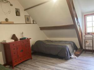 a bedroom with a bed and a dresser in a room at Cottage with Hot Tube & private Sauna with panoramic view in Les Moutiers-en-Cinglais