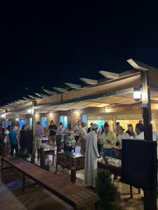 瓦迪拉姆的住宿－Rise Camp Wadi Rum，一群人晚上站在一家餐馆周围
