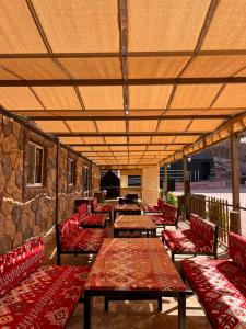瓦迪拉姆的住宿－Rise Camp Wadi Rum，庭院设有长凳、桌子和石墙