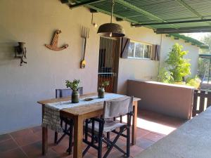 a table and chairs on a patio with a tub at Soetvlei Farm Cottage in Magaliesburg