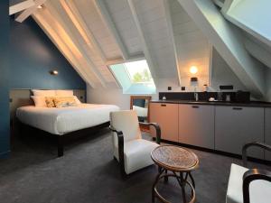 sypialnia z łóżkiem i kuchnia na poddaszu w obiekcie La Villa du Lac w mieście Aiguebelette-le-Lac