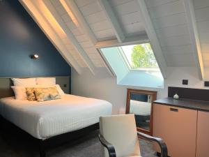 um quarto com uma cama com uma janela e uma cadeira em La Villa du Lac em Aiguebelette-le-Lac