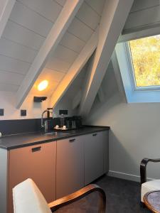 uma cozinha no sótão com um lavatório e uma janela em La Villa du Lac em Aiguebelette-le-Lac
