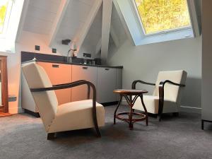 a kitchen with two chairs and a table and a window at La Villa du Lac in Aiguebelette-le-Lac