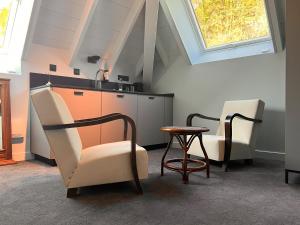 eine Küche mit 2 Stühlen, einem Tisch und einem Fenster in der Unterkunft La Villa du Lac in Aiguebelette-le-Lac