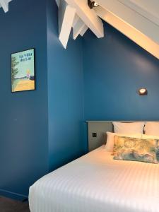 um quarto com uma parede azul e uma cama em La Villa du Lac em Aiguebelette-le-Lac