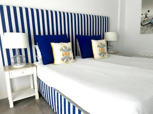 Una cama con almohadas azules y amarillas. en Hotel HS Milfontes Beach - Duna Parque Group, en Vila Nova de Milfontes