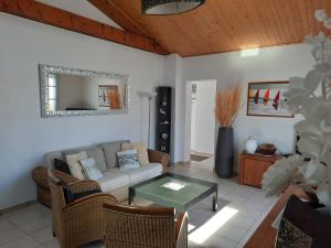una sala de estar con un sofá y una mesa en VILLA PRIVEE A 300M DE LA PLAGE, en Saint Gilles Croix de vie
