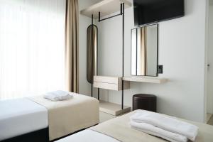 a bedroom with two beds and a mirror at Ashta Gold Suite in Fethiye