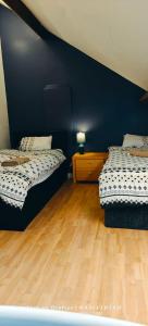 Habitación con 2 camas, paredes azules y suelo de madera. en St Lucia lodge Leicester long stays available en Leicester