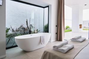 La salle de bains est pourvue d'une baignoire blanche et d'une grande fenêtre. dans l'établissement Ashta Gold Suite, à Fethiye 14 autres photos
