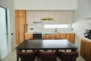 une cuisine avec une table noire et des chaises brunes dans l'établissement Ashta Gold Suite, à Fethiye