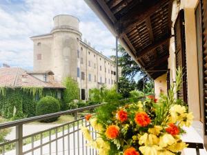 a balcony with flowers in front of a castle at Oryza Guest House in Desana