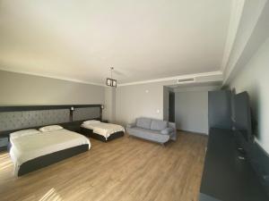 een slaapkamer met een bed en een stoel en een tv bij Carpediem Diamond Hotel in Karasu