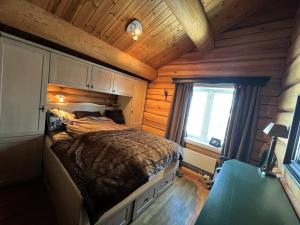 een slaapkamer met een bed in een houten hut bij Geilo centrum - cozy apartment - central location in Geilo