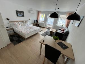 a bedroom with a bed and a table and a room at Ferienwohnungen und Appartements - Haus Budinger in Alf