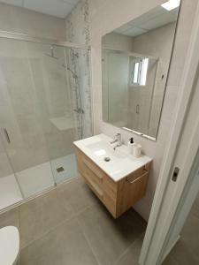 uma casa de banho branca com um lavatório e um chuveiro em Lofts Vial Norte em Córdoba