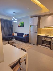 a living room with a blue couch and a kitchen at Luxury Studio - Damac Tower Amman in Amman