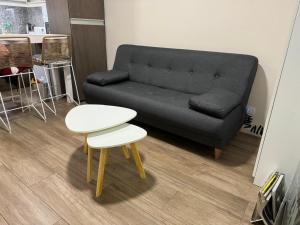 a living room with a black couch and a table at 2 ambientes moderno y muy bien ubicado in Buenos Aires