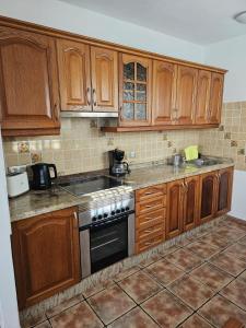 a kitchen with wooden cabinets and a stove at Casa Rosa in Famara