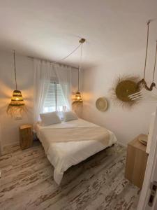 um quarto com uma cama com 2 candeeiros e uma janela em Zahora Beach Room em Zahora