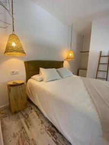 1 dormitorio con 1 cama blanca grande y 2 lámparas en Zahora Beach Room en Zahora