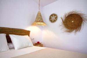 um quarto com uma cama com lençóis brancos e cestos em Zahora Beach Room em Zahora