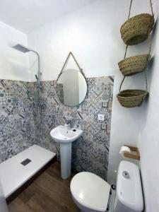 uma casa de banho com um lavatório, um WC e um espelho. em Zahora Beach Room em Zahora