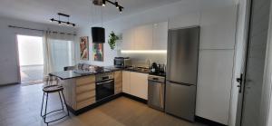 a kitchen with a refrigerator and a counter top at Villa Terranova in Mozaga