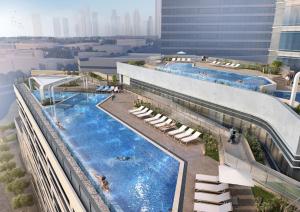 a building with two swimming pools in a city at Avani Plus Palm View Dubai Suites in Dubai