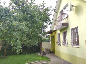 un edificio amarillo con 2 balcones y un patio en VIP Apartments 11 Kiev en Vyshhorod