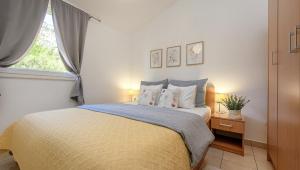 a bedroom with a bed with two pillows and a window at Villa Mare Komiža in Komiža