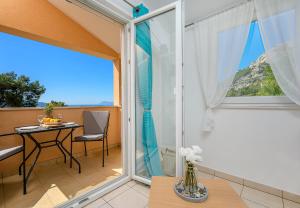 a room with a balcony with a table and a window at Villa Mare Komiža in Komiža